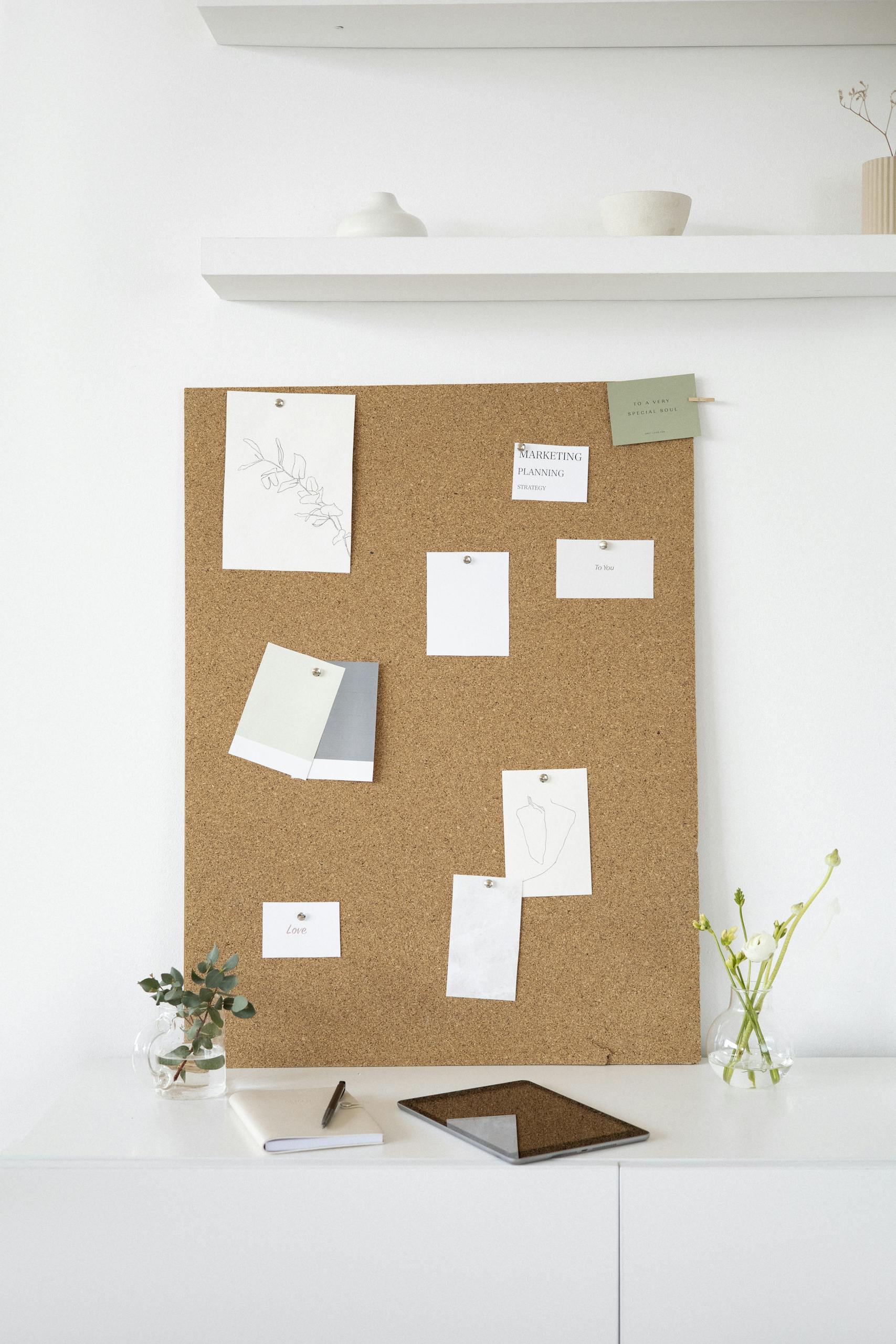 A clean and creative workspace featuring a cork board with notes, ideal for inspiration and design planning.