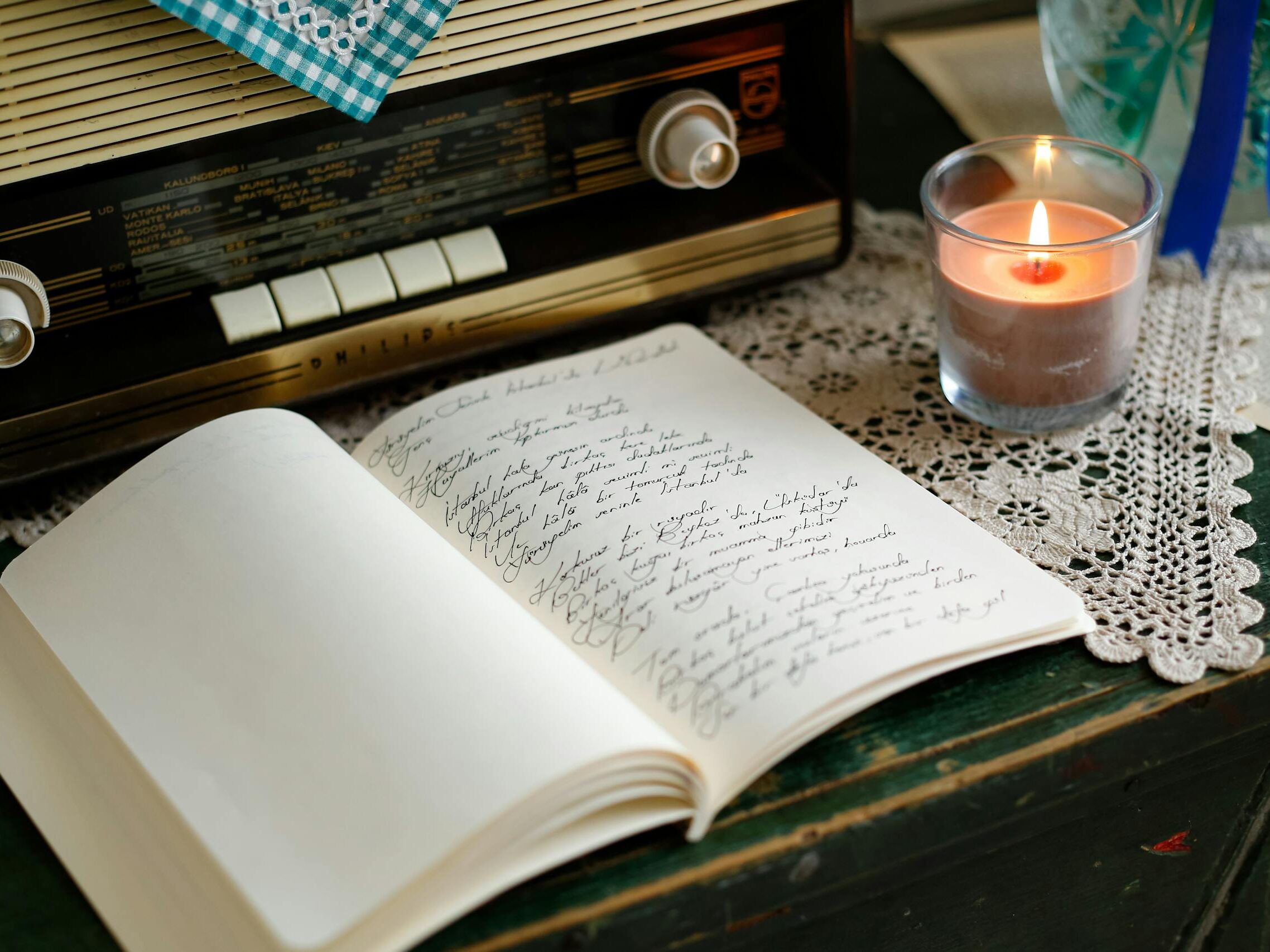 A vintage radio, candle, and journal create a nostalgic and cozy atmosphere indoors.